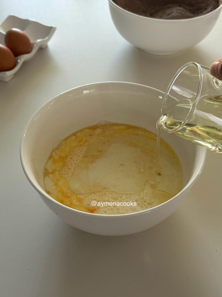 Eggs, milk, oil and vanilla whisked together for chocolate cake batter.