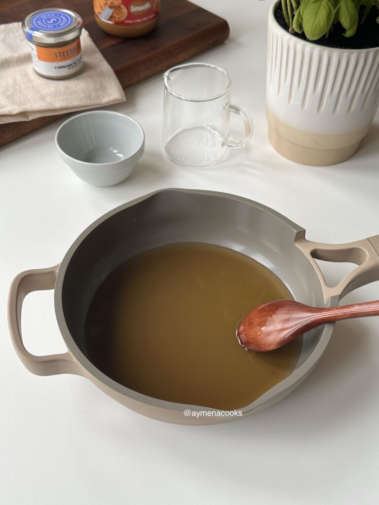 Light brown sugar dissolving in hot water over gentle heat to make a simple syrup.