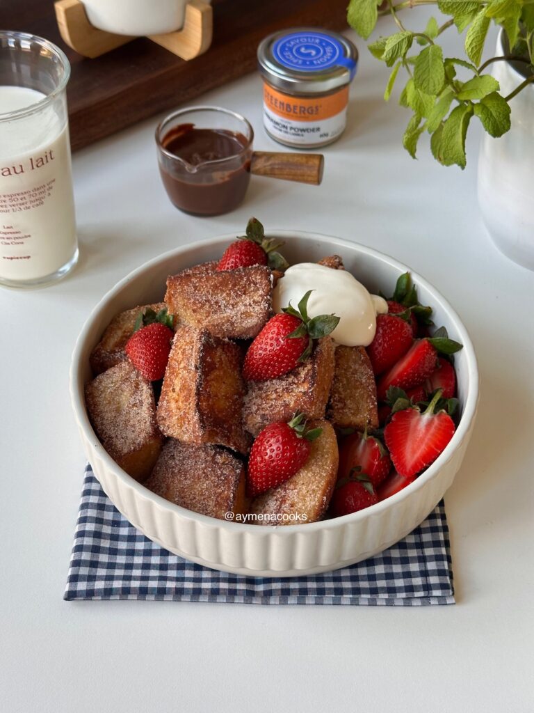 Golden French toast bites coated in cinnamon sugar and served with fresh strawberries and whipped cream.