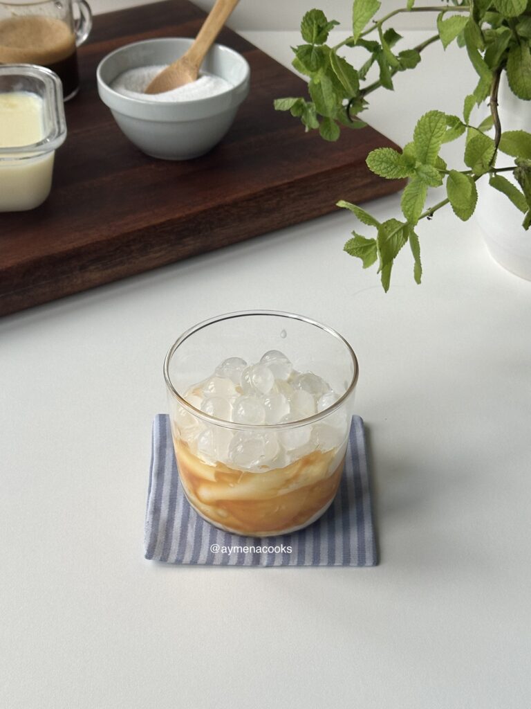 milk poured into a glass with ice and caramel sauce