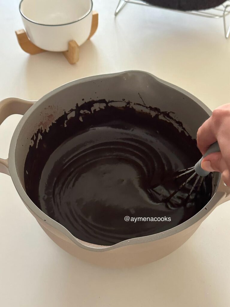 Hot fudge frosting being whisked until smooth and thick after the dark chocolate and butter has been added.