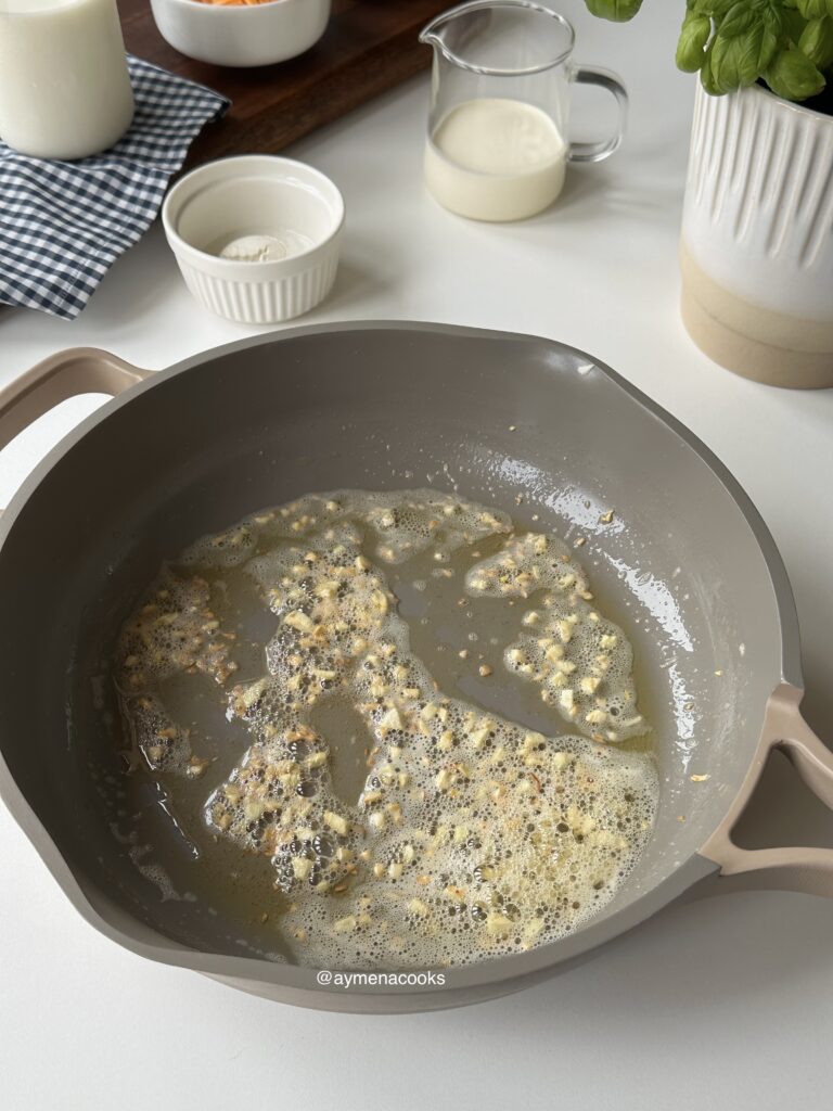 Fresh garlic cooking gently in melted butter for mac and cheese.