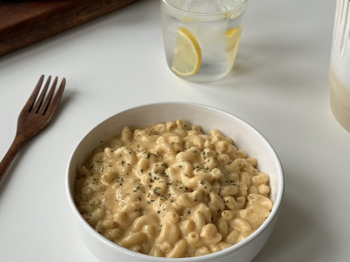 Creamy stovetop mac and cheese with macaroni coated in a glossy three-cheese sauce served in a bowl.