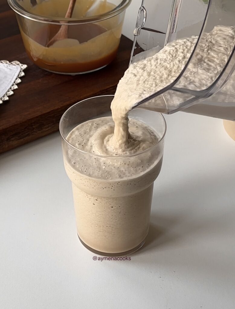 Thick smooth caramel frappe blended with coffee, milk, ice and caramel being poured into a glass.