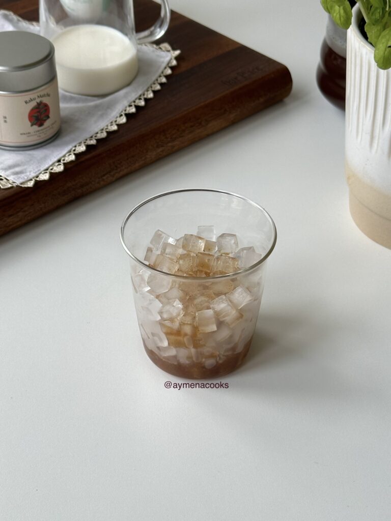 Banana bread syrup poured over ice in a tall glass.