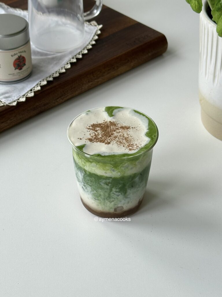 Layered iced banana matcha topped with creamy banana cold foam and a light dusting of cinnamon.