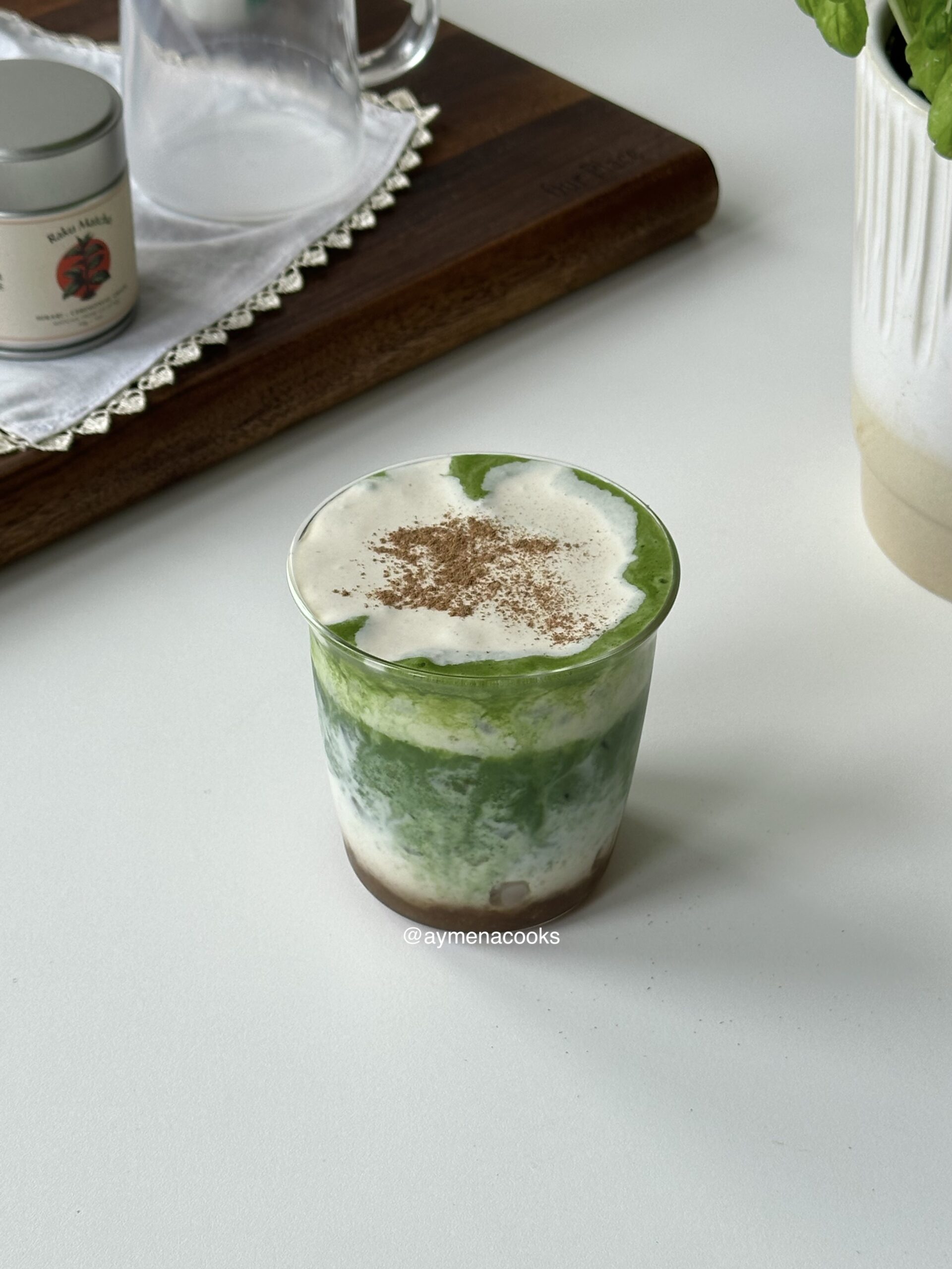 Layered iced banana matcha topped with creamy banana cold foam and a light dusting of cinnamon.