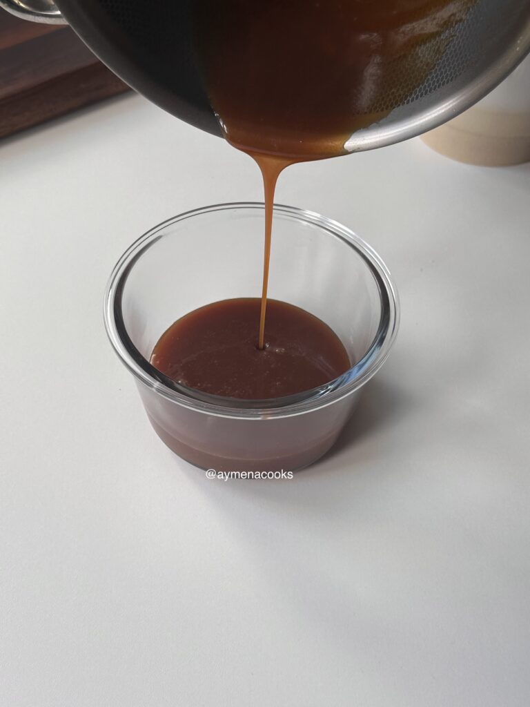 Warm homemade caramel sauce poured into a heatproof container.