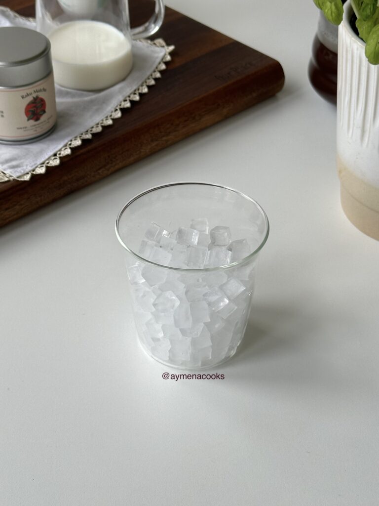 A tall glass generously filled with mini ice cubes.