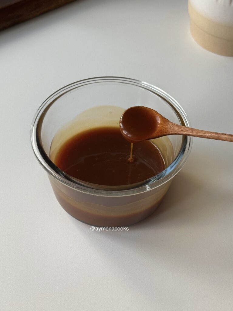 Warm caramel sauce falling from a spoon.