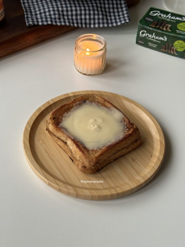 Cream cheese frosting spread over warm cinnamon roll French toast.