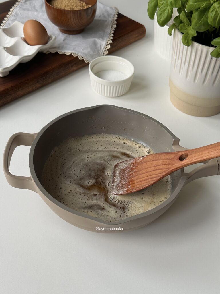 Browned butter with toasted golden milk solids in a saucepan.