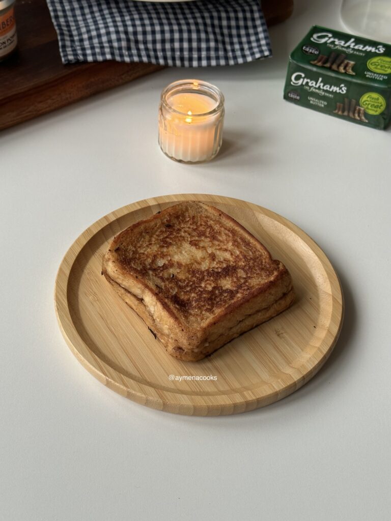 Golde cinnamon roll French toast sandwich cooked until golden and removed from pan.