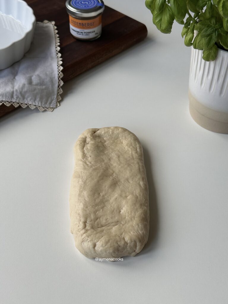 Cinnamon roll dough shaped into a thick rectangle.